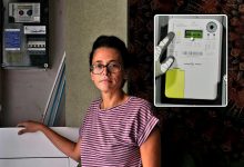 Mechelen woman beside her electricity meter during a dispute over a digital meter.