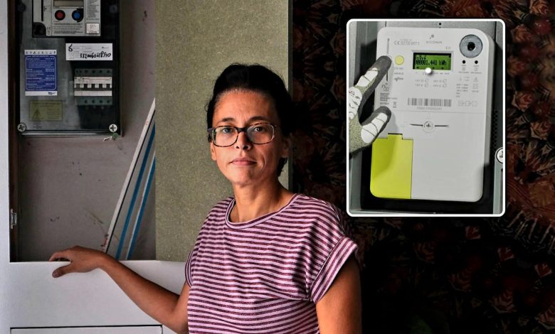 Mechelen woman beside her electricity meter during a dispute over a digital meter.